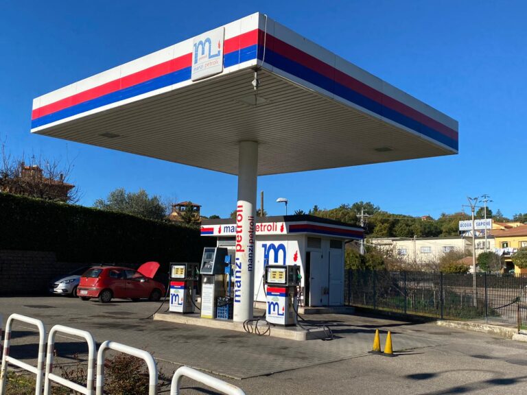 Stazione di servizio con auto rossa parcheggiata.